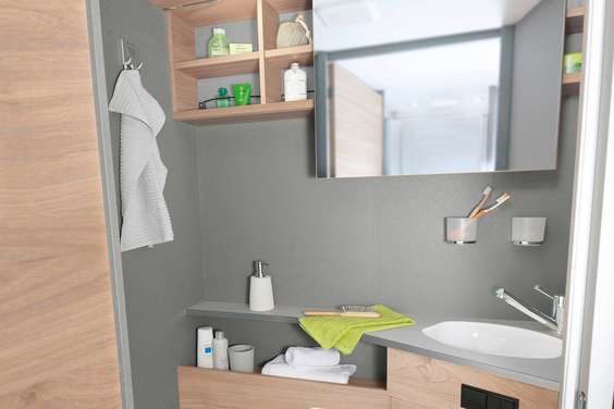 Bright and modern washroom with practical mirror that can be moved sideways, as well as numerous shelves and storage options