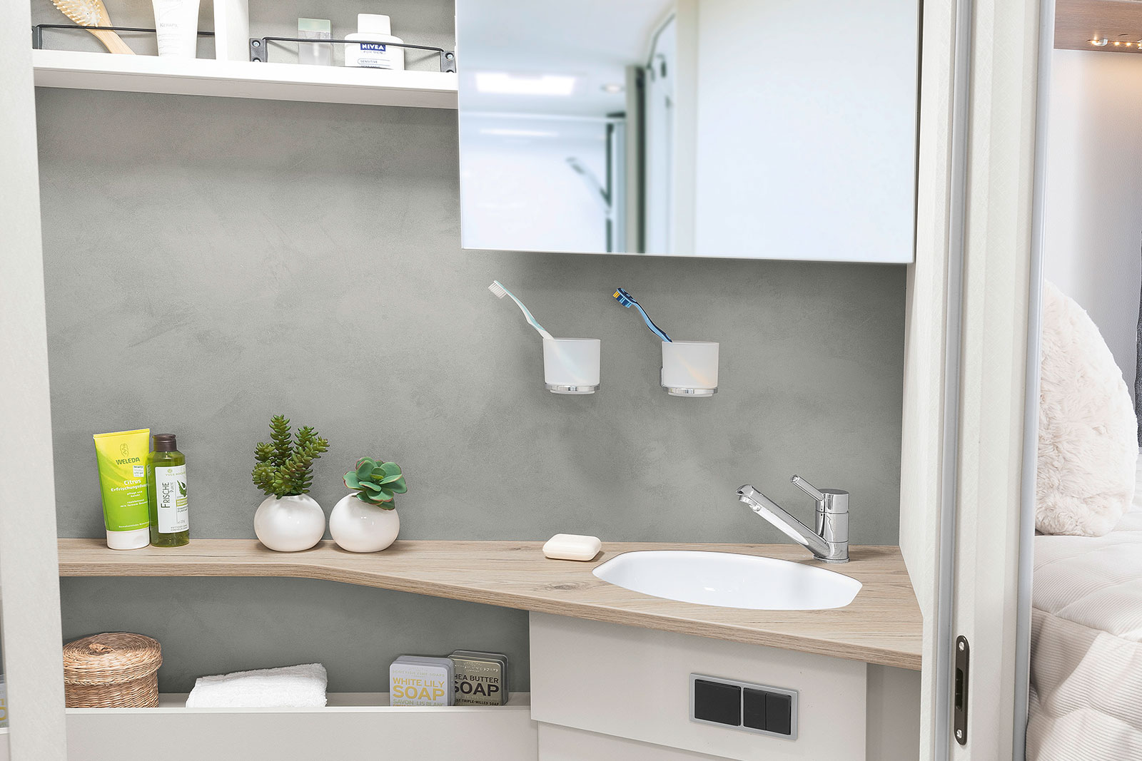 Bright and modern washroom with practical mirror that can be moved sideways, as well as numerous shelves and storage options • I 7057 EB